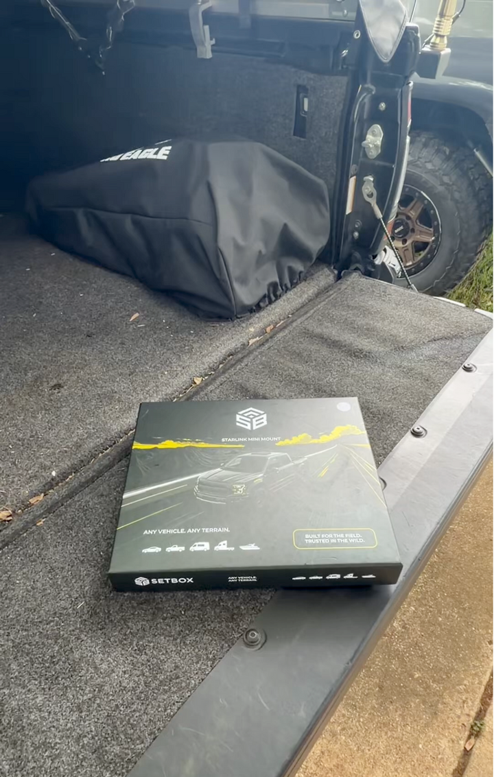 SETBOX retail box on the open tailgate of a pickup, gear bag and spare wheel behind