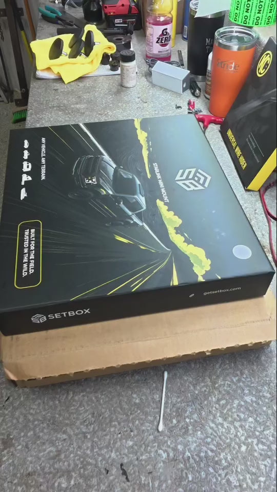The SETBOX retail box on a workbench in a garage, tools and a drill behind it