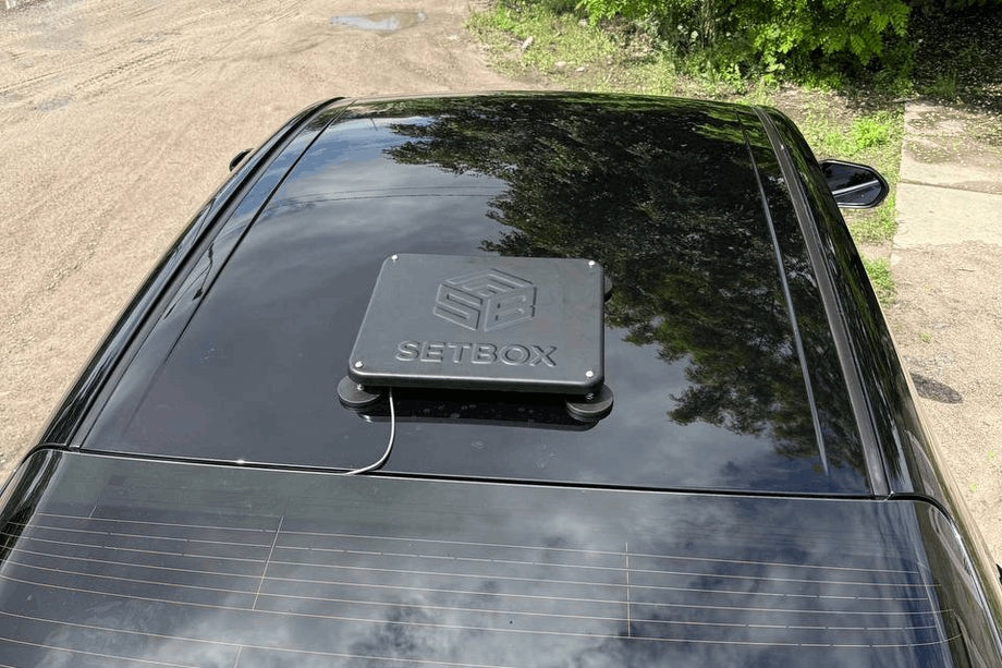 Black housing on a car roof, street behind