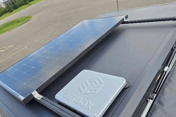 Grey housing on a car roof next to a solar panel